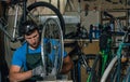 Competent bicycle mechanic in a workshop repairs a bike. Royalty Free Stock Photo