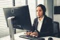 Competent female operator working on computer and while talking with clients. Royalty Free Stock Photo