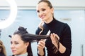 Hairdresser cutting and styling hair of woman in her shop Royalty Free Stock Photo