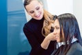 Hairdresser cutting and styling hair of woman in her shop Royalty Free Stock Photo