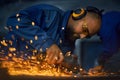 Worker polishing metal product using angle grinder