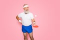 Competetive emotional cool active comic grandpa with beaming grin, with table tennis equipment. Healthcare, weight loss Royalty Free Stock Photo