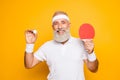 Competetive emotional cool active goofy comic grey haired grandpa with humor grimace and beaming grin, with table tennis Royalty Free Stock Photo