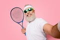 Competetive emotional cool grandpa with humor grimace exercising holding equipment, shoting photo. Body care, healthcare