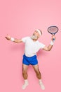 Competetive emotional cool grandpa with humor grimace exercising holding equipment, swatting ball with strength and