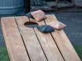 Competing black and beige beanbags sitting on cornhole platform Royalty Free Stock Photo