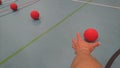 Reaching out a hand for a red dodgeball Royalty Free Stock Photo