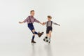 Competition. Boys, children in classical retro clothes playing football over grey studio background. Concept of game Royalty Free Stock Photo