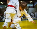 Competition at judo school, two little wrestling boys in the fight, close-up