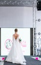 Competition of wedding stylists. A model in a white wedding dress with an open back, with a hairdo and a bouquet in her Royalty Free Stock Photo