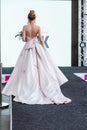 Competition of wedding stylists. A model in a white wedding dress with an open back, with a hairdo and a bouquet in her Royalty Free Stock Photo