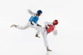 Competitive strong young men, taekwondo, karate athletes in motion, fighting, training over white background