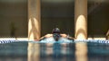 Competitive swimmer executing butterfly stroke in indoor swimming pool Royalty Free Stock Photo