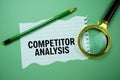 Competitor Analysis quotes text on paper torn with magnifying glass top view on green background Royalty Free Stock Photo