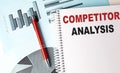 COMPETITOR ANALYSIS text on a notebook with pen on a chart background Royalty Free Stock Photo