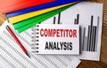 COMPETITOR ANALYSIS text on a notebook with pen, folder on a chart background Royalty Free Stock Photo