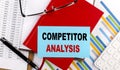 COMPETITOR ANALYSIS text on a sticky on red notebook on chart background Royalty Free Stock Photo