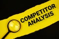 Competitor Analysis text on yellow with black paper torn ripped and magnifying glass Royalty Free Stock Photo