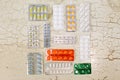 Compisition of different blister packs of tablets on ancient white wooden table