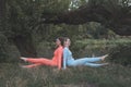 Two happy young girlfriends practice yoga outdoors Royalty Free Stock Photo