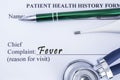 Complaint of Fever. Paper health history form, which is written on the patients chief complaint of Fever, surrounded by a stethosc