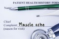 Complaint of muscle ache. Paper health history form, which is written on the patient`s chief complaint of muscle ache, surrounded