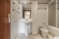 A complete bathroom with showers with screens, white column furniture