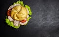 Complete deli sandwich filled with ham slices salad and tomato over dark background with copy space Royalty Free Stock Photo