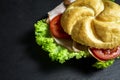 Complete deli sandwich filled with ham slices salad and tomato over dark background with copy space Royalty Free Stock Photo