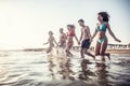 The complete family runs hand in hand from the beach to the sea, enjoying a joint vacation by the sea Royalty Free Stock Photo