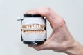 Complete full denture in man`s hand. Dental prosthesis design