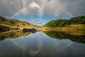 A complete rainbow and its reflection in the river Royalty Free Stock Photo