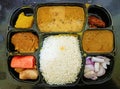 A complete vegetarian Indian thali containing rice, daal, curry, sweet, mashed potato, salad etc.