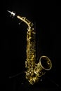 A complete view of a gold saxophone with mechanisms and buttons,