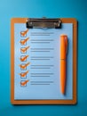 A completed checklist on a clipboard with bold orange checkmarks and a matching orange pen placed on a blue background Royalty Free Stock Photo