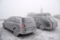 Completely frozen and snow-covered passenger car in a parking lot in winter in a thick fog