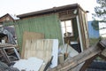 Completely ruined house, broken windows. Garbage, tires, wooden boards, pieces of plywood