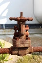 Completely rusted metal pipe connection with strong fully closed valve at abandoned industrial complex