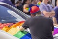 A man wears a gay pride unique cat hat.