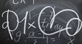 Complex math equations are scribbled on a dark blackboard Royalty Free Stock Photo