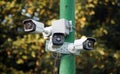 A complex of outdoor surveillance cameras on a pole in the park.