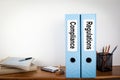 Compliance and Regulations binders in the office. Stationery on a wooden shelf Royalty Free Stock Photo