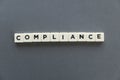 Compliance word made of square letter word on grey background. Royalty Free Stock Photo