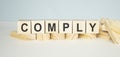 Comply word on wooden cubes on a light Royalty Free Stock Photo