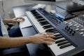 Composer hands on piano keys in recording studio. music production technology, man is working on pianino and computer