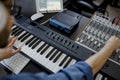 Composer hands on piano keys in recording studio. music production technology, man is working on pianino and computer