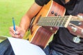 Composer write note of song and use acoustic guitar Royalty Free Stock Photo