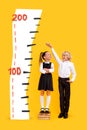 Composite collage of two schoolkids measure height isolated on creative drawing yellow background