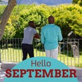 Composite of hello september text over african american father and son in garden