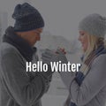 Composite of hello winter text over happy caucasian couple in winter scenery